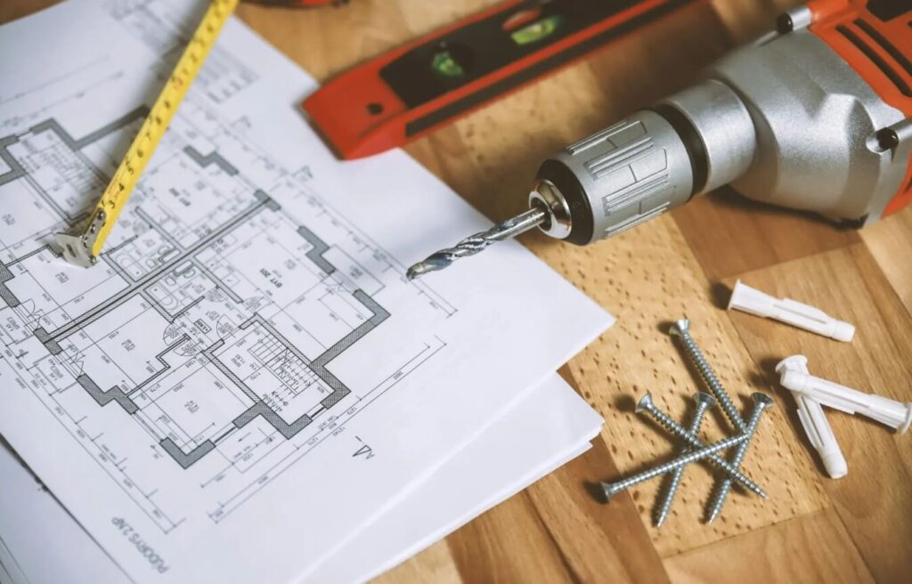 Pomiary i przygotowanie do montażu osłon okiennych - projekt techniczny, poziomica, wkrętarka oraz elementy montażowe używane przy instalacji zasłon i firan na wymiar w Zielonej Górze